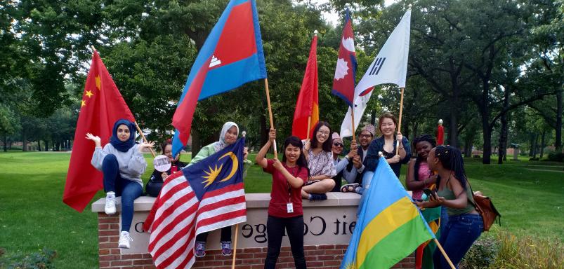 毕业典礼结束后，国际学生在皇冠crown体育的标志前挥舞着他们的旗帜...